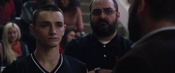 Movie still from “The Way Back” (2020), directed by Gavin O'Connor – A man and a boy are watching a basketball game; Close Up shot, Over the shoulder angle
