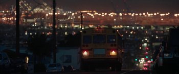 Movie still from “The Way Back” (2020), directed by Gavin O'Connor – A school bus driving down a street at night; Extreme Wide shot, Low angle