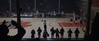 Movie still from “The Way Back” (2020), directed by Gavin O'Connor – A group of cheerleaders standing on a basketball court; Extreme Wide shot, High angle