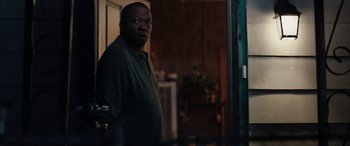 Movie still from “The Way Back” (2020), directed by Gavin O'Connor – A man standing in front of a door in a room; Medium shot, Over the shoulder angle