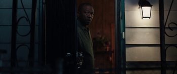 Movie still from “The Way Back” (2020), directed by Gavin O'Connor – A man standing next to a door in a room; Medium shot, Over the shoulder angle