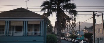 Movie still from “The Way Back” (2020), directed by Gavin O'Connor – Palm trees in front of a house on a residential street; Extreme Wide shot, Low angle