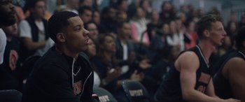 Movie still from “The Way Back” (2020), directed by Gavin O'Connor – A crowd of people watching a basketball game in progress; Close Up shot, Over the shoulder angle