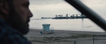 Movie still from “The Way Back” (2020), directed by Gavin O'Connor – A lifeguard tower on the beach near the water; Extreme Wide shot, High angle