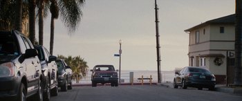 Movie still from “The Way Back” (2020), directed by Gavin O'Connor – A car parked on the side of the road near the beach; Extreme Wide shot, High angle
