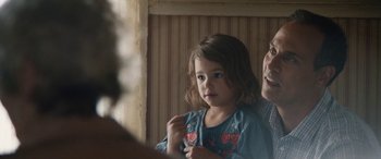 Movie still from “The Way Back” (2020), directed by Gavin O'Connor – A little girl standing in front of a mirror with an older man; Close Up shot, Over the shoulder angle