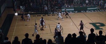 Movie still from “The Way Back” (2020), directed by Gavin O'Connor – A group of men playing a game of basketball on a basketball court; Extreme Wide shot, High angle
