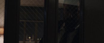 Movie still from “The Way Back” (2020), directed by Gavin O'Connor – A man standing next to a window at night; Close Up shot, Over the shoulder angle
