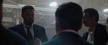 Movie still from “The Way Back” (2020), directed by Gavin O'Connor – A man in a suit is talking to another man in front of a mirror; Close Up shot, Over the shoulder angle