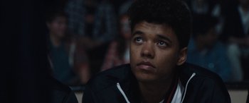 Movie still from “The Way Back” (2020), directed by Gavin O'Connor – A young man looking up while sitting in a room; Close Up shot, Low angle