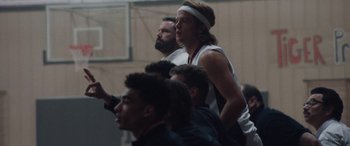 Movie still from “The Way Back” (2020), directed by Gavin O'Connor – A group of young men playing a game of basketball; Medium shot, Over the shoulder angle