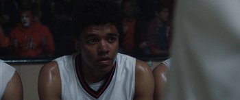 Movie still from “The Way Back” (2020), directed by Gavin O'Connor – A young man in a white shirt is looking at the camera; Close Up shot, Over the shoulder angle