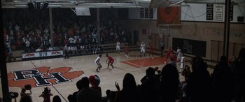 Movie still from “The Way Back” (2020), directed by Gavin O'Connor – A group of men playing basketball on a court; Extreme Wide shot, High angle