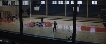 Movie still from “The Way Back” (2020), directed by Gavin O'Connor – Two men are playing basketball in a gymnasium; Extreme Wide shot, High angle