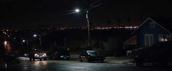 Movie still from “The Way Back” (2020), directed by Gavin O'Connor – Two cars are parked in a parking lot under a street light; Extreme Wide shot, High angle