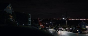 Movie still from “The Way Back” (2020), directed by Gavin O'Connor – A person walking down a street at night; Extreme Wide shot, High angle