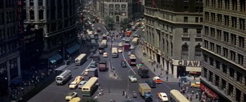 Movie still from “The Way We Were” (1973), directed by Sydney Pollack – An aerial view of a busy city street with buses , cars , and pedestrians; Extreme Wide shot, High angle
