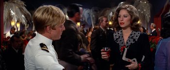 Movie still from “The Way We Were” (1973), directed by Sydney Pollack – A group of people standing around a room with drinks; Medium shot, Over the shoulder angle