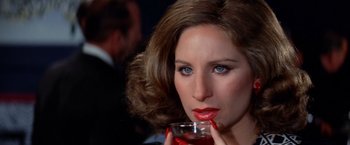Movie still from “The Way We Were” (1973), directed by Sydney Pollack – A beautiful woman holding a drink in her hand; Close Up shot, High angle