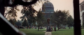 Movie still from “The Way We Were” (1973), directed by Sydney Pollack – A group of people in a park with a statue of a man; Extreme Wide shot, High angle