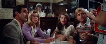 Movie still from “The Way We Were” (1973), directed by Sydney Pollack – Two women sitting at a table in front of a mirror; Medium shot, Over the shoulder angle