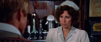 Movie still from “The Way We Were” (1973), directed by Sydney Pollack – A person in a kitchen area; Close Up shot, Over the shoulder angle