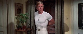Movie still from “The Way We Were” (1973), directed by Sydney Pollack – A man in a white shirt is standing in front of a door; Medium shot, Low angle