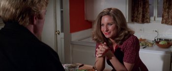 Movie still from “The Way We Were” (1973), directed by Sydney Pollack – A woman sitting at a dinner table with her hands clasped together; Close Up shot, High angle