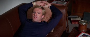 Movie still from “The Way We Were” (1973), directed by Sydney Pollack – A man laying on a couch with his hands behind his head; Close Up shot, High angle