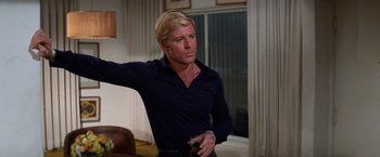 Movie still from “The Way We Were” (1973), directed by Sydney Pollack – A man with blonde hair is holding a cell phone; Medium shot, Low angle