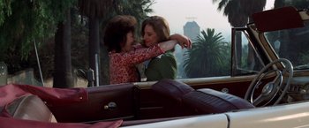 Movie still from “The Way We Were” (1973), directed by Sydney Pollack – Two young women embracing each other while sitting in a car; Medium shot, High angle