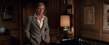 Movie still from “The Way We Were” (1973), directed by Sydney Pollack – A man standing in a living room with a lamp; Medium shot, Low angle