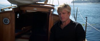 Movie still from “The Way We Were” (1973), directed by Sydney Pollack – A man sitting on top of a boat in the water; Close Up shot, Low angle