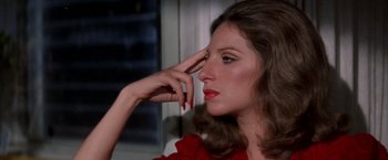Movie still from “The Way We Were” (1973), directed by Sydney Pollack – A beautiful woman in a red dress touching her face; Close Up shot, High angle