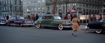 Movie still from “The Way We Were” (1973), directed by Sydney Pollack – An old car is parked on the side of the street; Wide shot, High angle