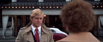 Movie still from “The Way We Were” (1973), directed by Sydney Pollack – A man in a trench coat talking to a woman in front of a building; Close Up shot, Over the shoulder angle