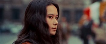 Movie still from “The Way of the Dragon” (1972), directed by Bruce Lee – A woman with long black hair is looking into the distance; Close Up shot, Over the shoulder angle