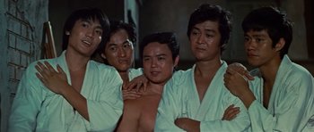 Movie still from “The Way of the Dragon” (1972), directed by Bruce Lee – A group of men standing next to each other; Medium shot, Low angle
