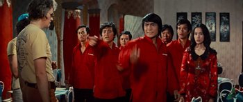 Movie still from “The Way of the Dragon” (1972), directed by Bruce Lee – A group of men in red shirts standing in a room; Medium shot, Low angle