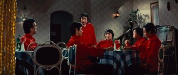Movie still from “The Way of the Dragon” (1972), directed by Bruce Lee – A group of people sitting around a table; Medium shot, High angle