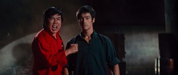 Movie still from “The Way of the Dragon” (1972), directed by Bruce Lee – A man in a red shirt and a man in a black shirt; Medium shot, Low angle