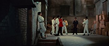 Movie still from “The Way of the Dragon” (1972), directed by Bruce Lee – A group of people walking down a street; Wide shot, Low angle