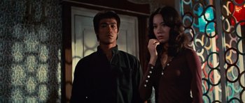Movie still from “The Way of the Dragon” (1972), directed by Bruce Lee – A man and a woman standing next to each other; Medium shot, Low angle