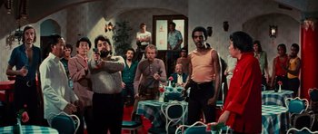 Movie still from “The Way of the Dragon” (1972), directed by Bruce Lee – A group of people standing around a room; Wide shot, High angle