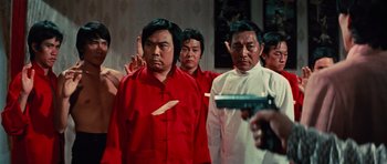 Movie still from “The Way of the Dragon” (1972), directed by Bruce Lee – A group of men standing next to each other in a room; Medium shot, Low angle