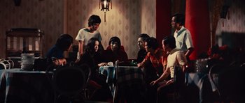 Movie still from “The Way of the Dragon” (1972), directed by Bruce Lee – A group of people sitting around a table; Medium shot, High angle