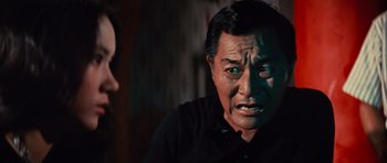 Movie still from “The Way of the Dragon” (1972), directed by Bruce Lee – An older asian man is looking at a younger asian woman; Close Up shot, Over the shoulder angle