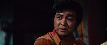 Movie still from “The Way of the Dragon” (1972), directed by Bruce Lee – A person wearing an orange shirt; Close Up shot, Low angle