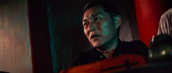 Movie still from “The Way of the Dragon” (1972), directed by Bruce Lee – A man's face in a dark room; Close Up shot, Low angle