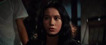 Movie still from “The Way of the Dragon” (1972), directed by Bruce Lee – A woman with long black hair is looking at the camera; Close Up shot, Low angle